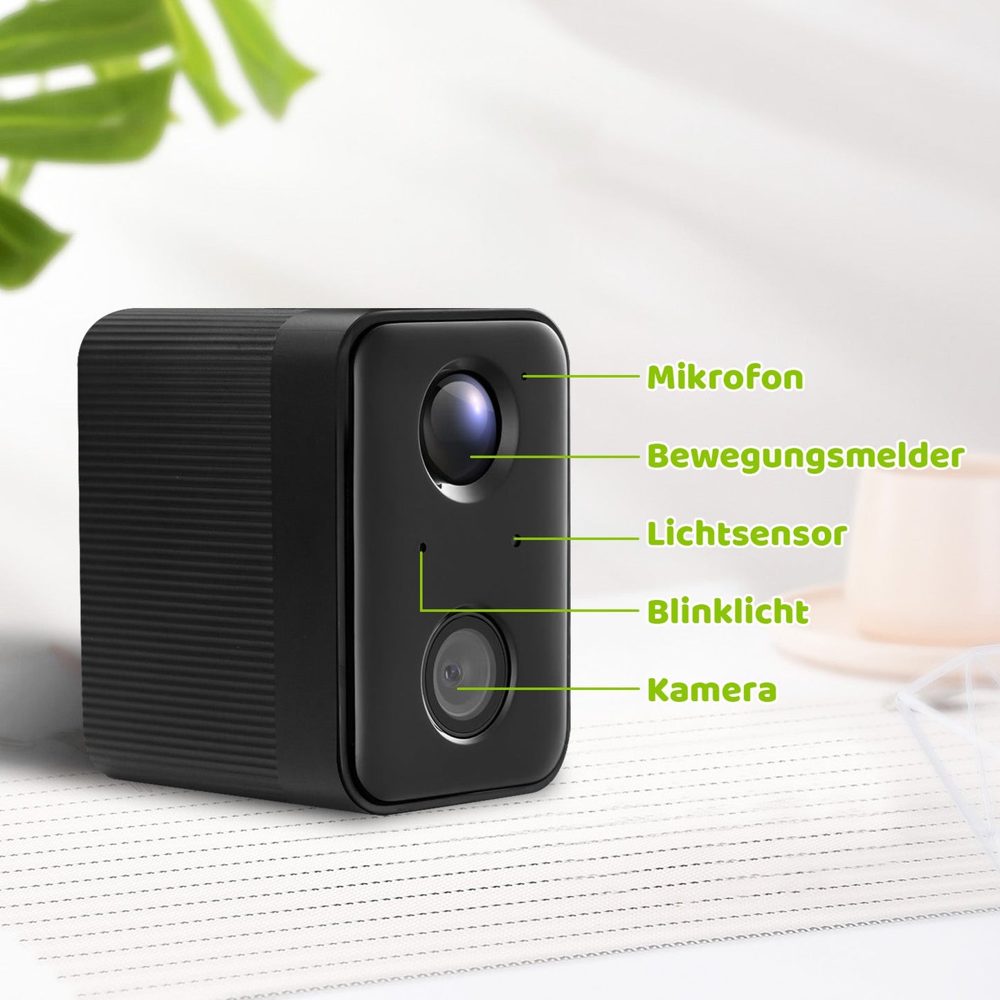 Schwarze kompakte Überwachungskamera mit zwei Linsen und grünen Beschriftungen, die Mikrofon, Bewegungsmelder, Lichtsensor, Blinklicht und Kamera markieren